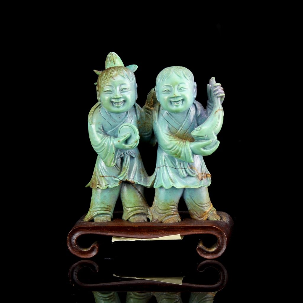 Chinese Turquoise Figures: China, 19th C., turquoise figures, two children, standing on a wood base, each holding an object in their hands, with a large smile on their faces. Height 2 1/4 in.