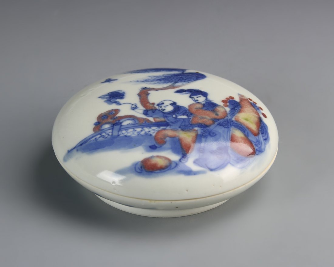 Chinese Copper Red Ink Box: China, Kangxi period, copper red ink box, with lid in a circular form, with illustration of two figures in blue and copper red glaze, over a white ground with high shine surface, mark on base. Diamete