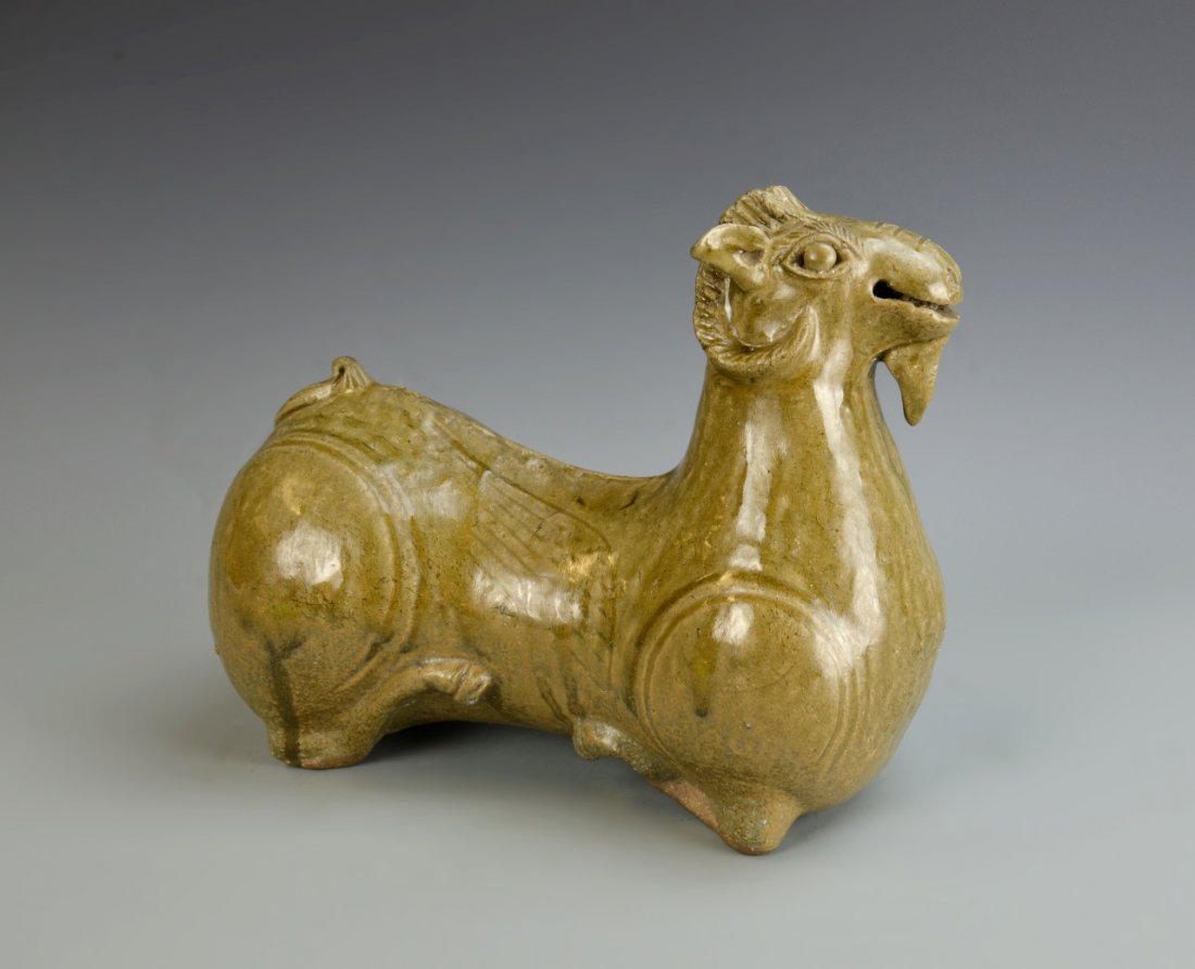 Chinese Qin Glazed Ram: China, Jin Period, Qin glazed ram, in a seated position, with a long extended neck, with rounded hips and shoulders, in a yellow-brown hue, with a high shine glaze. Height 8 3/4 in., Length 10 in.