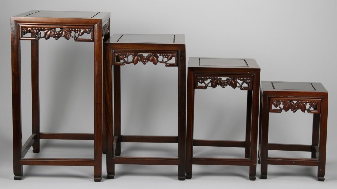 Four Chinese Huanghuali Nesting Tables: China,19th C., a set four Huanghuali nesting tables, each carved with hanging detail in the form of fruit and vines, range of light to dark natural brown wood shades. Largest Height 25 7/8 in. Width 2