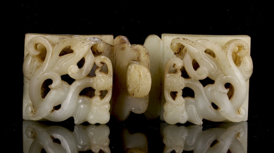 Chinese Jade Buckle: China, jade buckle, two pieces. Buckles have white coloring, auspicious design with intricate carving on front of buckle, top of right one has engraved pattern on clasp, Height 2 1/2 in., Width 1 3/4 
