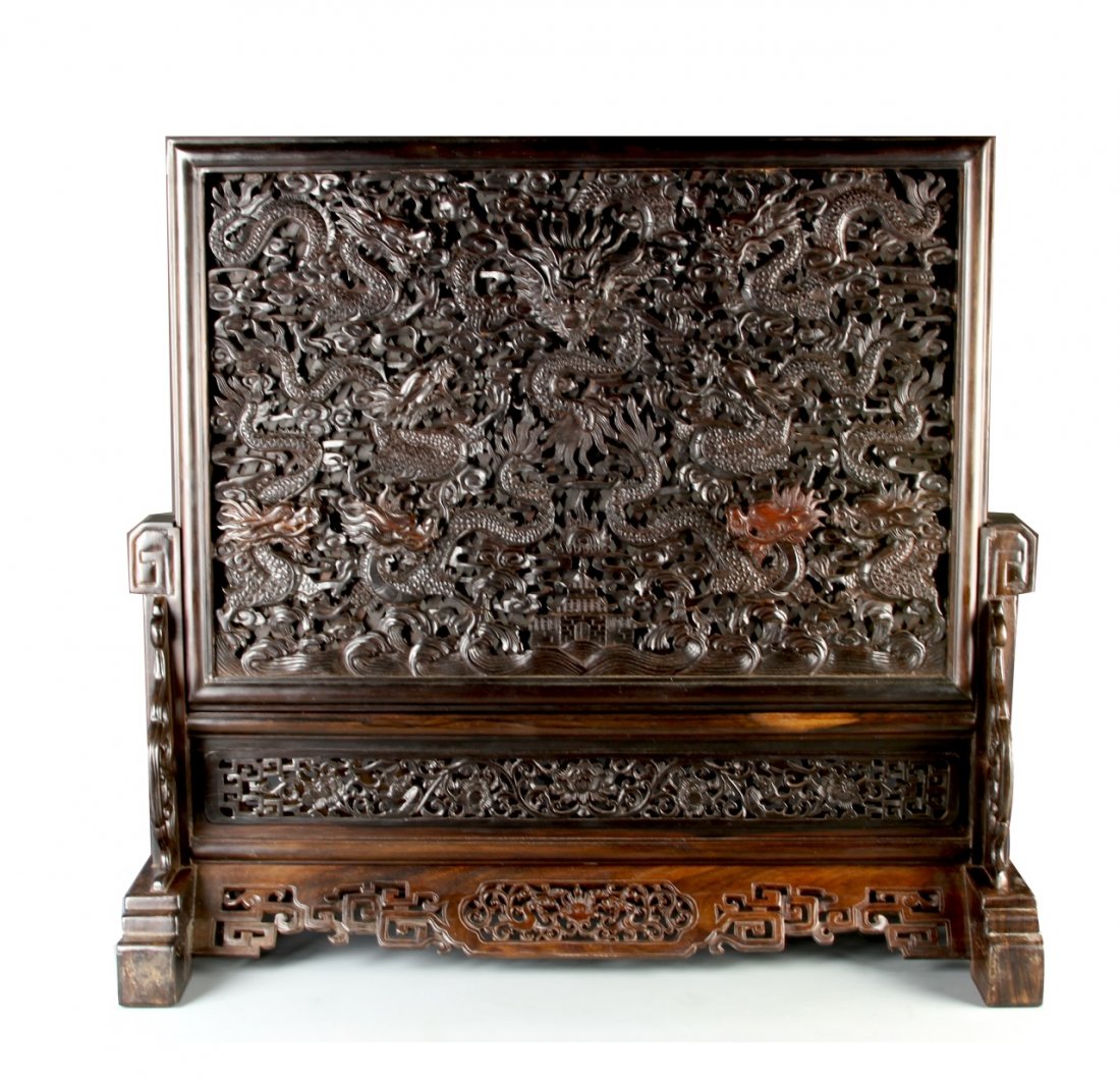 Chinese Carved Hardwood Table Screen: China, carved hardwood table screen, with densely patterned decoration in the form of dragons on a partially openwork design. Length 24 1/4 in., Height 24 1/2 in.