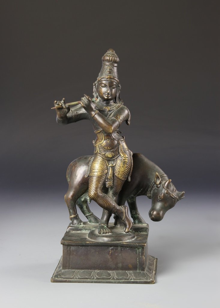 Southeast Asian Antique Bronze Lady Figure: Southeast Asia, antique bronze lady figure, figure playing a flute and wearing an elaborate headdress standing in front of an ox on a square plain base, partial gilt. Height 12 in.