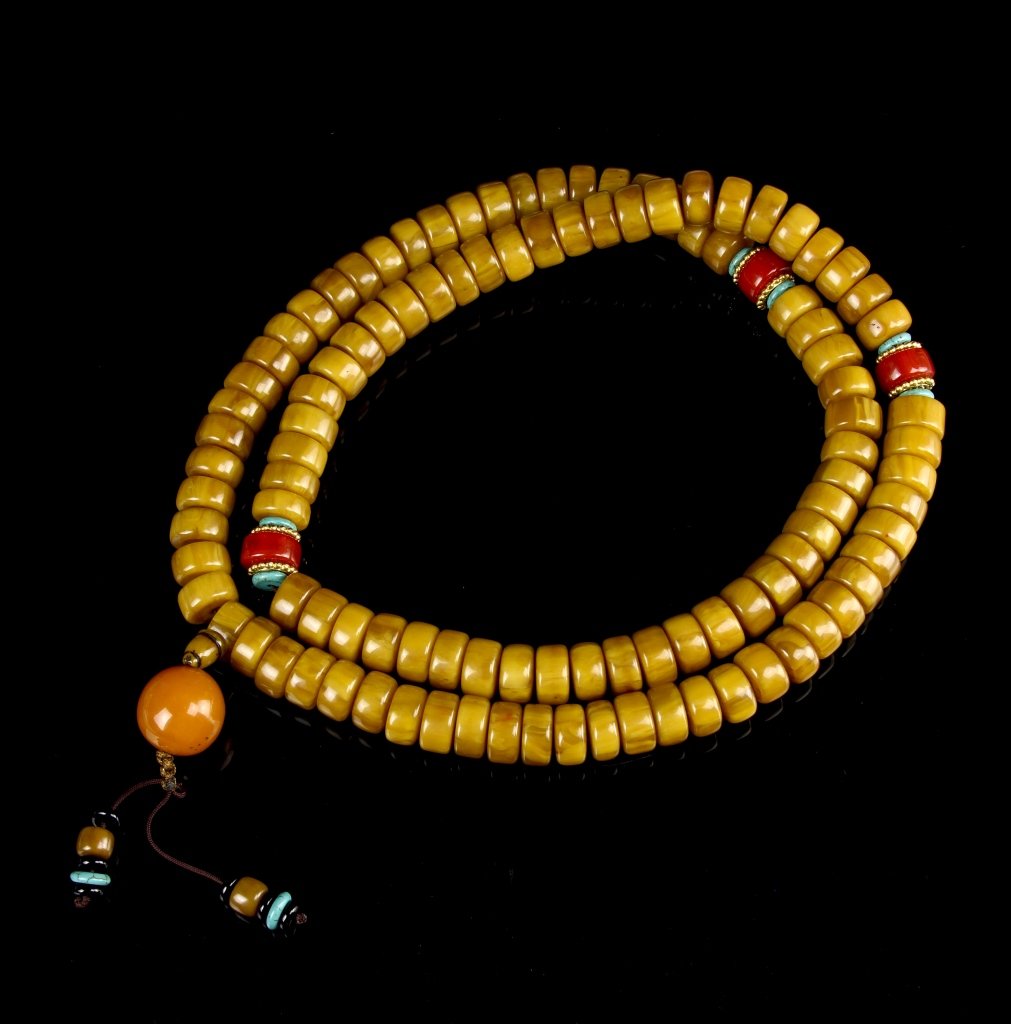 Chinese Tibetan Necklace: China, Tibet, necklace, two strings of ochre colored beads of the same shape and size, with three bright blue larger beads and one tasseled extension. Length 38 in.