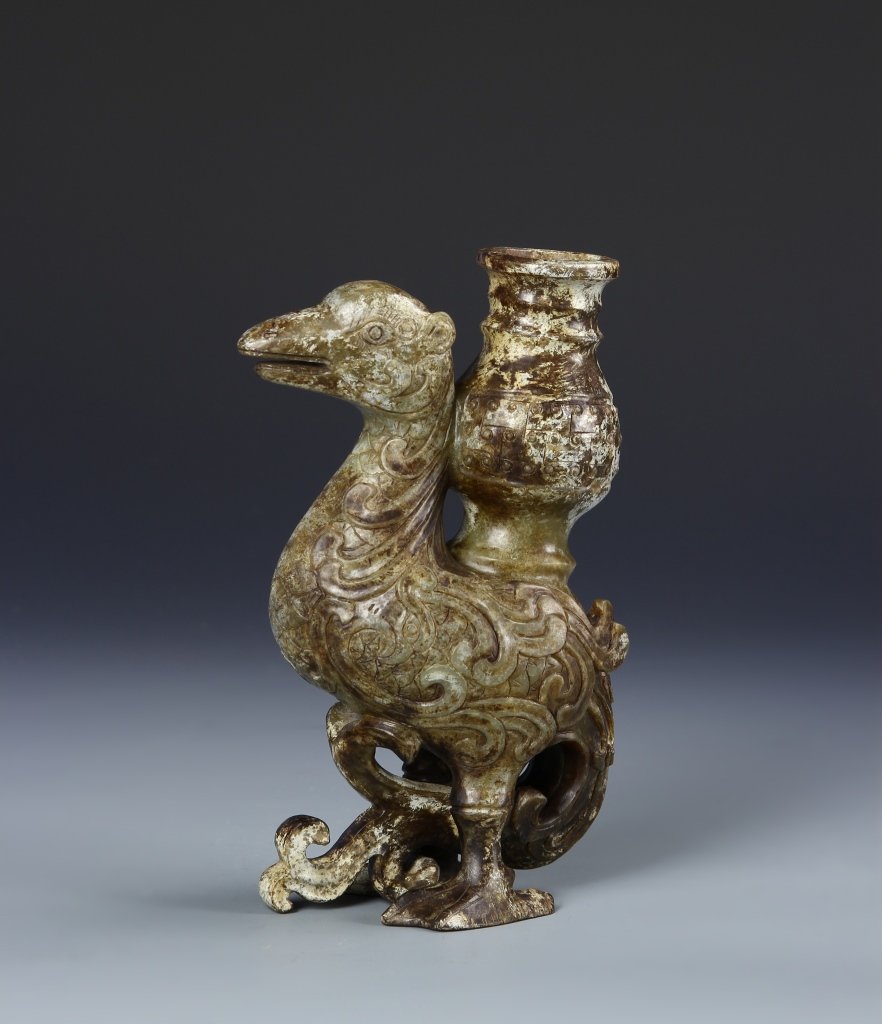 Chinese Jade Bird: China, jade bird, carved decoration of a scroll pattern throughout the body, attached with a tubular vase. Height 7 1/2 in. Provenance: private collection from Cape Cod, MA.