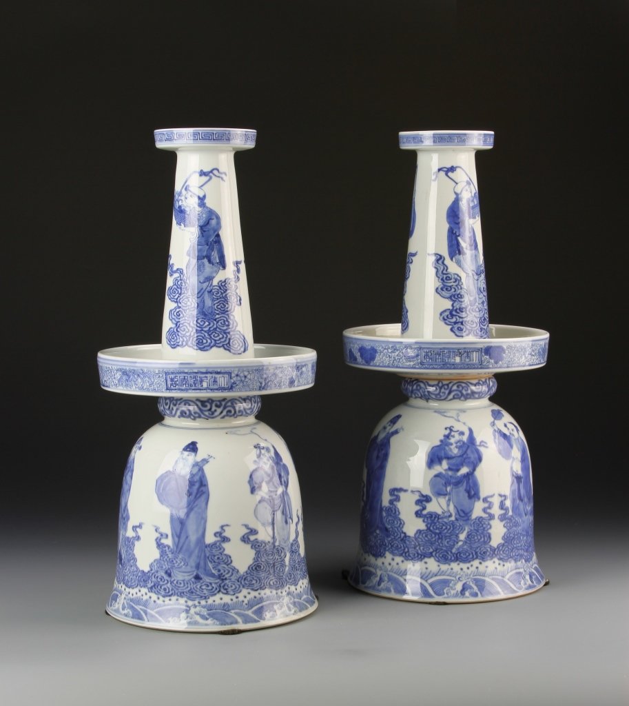 Pair of Chinese Blue and White Candle Holders: China, 19th C., pair of blue and white candle holders, white ground painted with multiple figures standing atop swirling clouds in a blue hue, minor hairlines. Height 15 1/8 in.