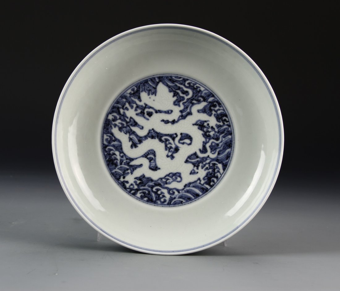 Chinese Blue and White Dragon Plate: China, blue and white dragon plate, silhouette of a white dragon flying through ruyi clouds, thin blue line around the rim, Xuede mark. Diameter 8 3/4 in.
