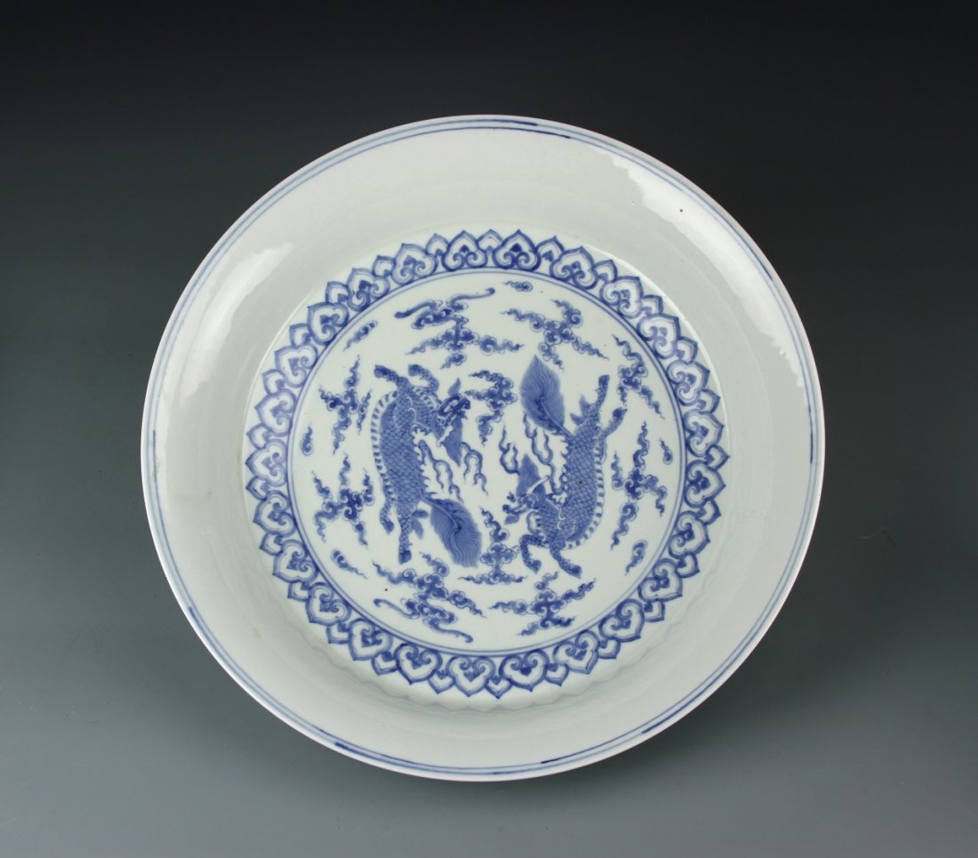 Chinese Blue and White Charger: China, blue and white charger, on a slightly raised base, blue dragon designs on interior and exterior, double ring mark on interior rim, with Kyln painting. Diameter 16 in.