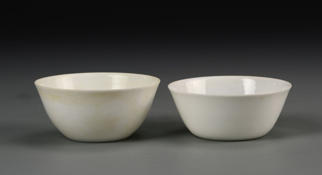 Two Chinese Ming Anhua Wine Cups: China, Ming dynasty, pair of wine cups, each with anhua decorations of chasing dragons, Ming mark on base, the larger cup 3.2 in diameter. Provenance: Estate of James Fould, Potomac, Maryland.