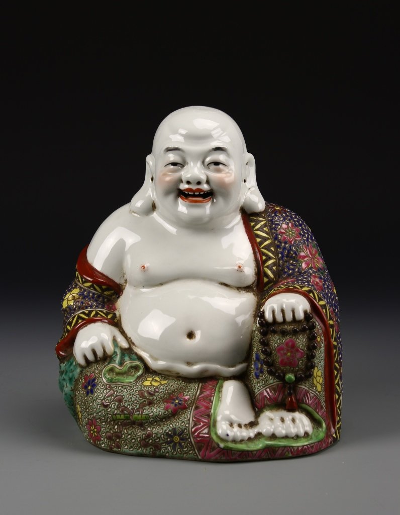 Chinese Famille Rose Buddha: China, ROC period, famille rose Buddha, bald and barefoot, seated and happy with loose floral robes and holding prayer beads, with mark on base. Height 11 in.