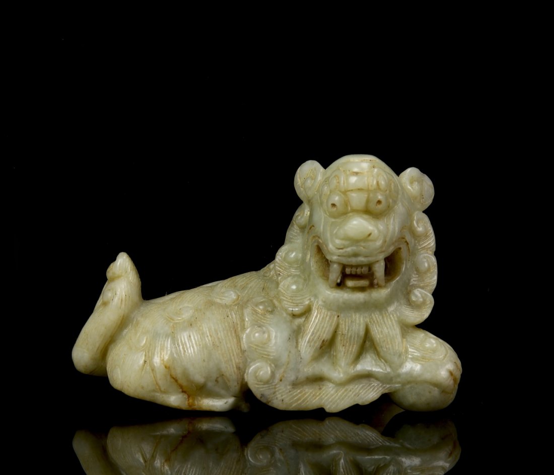 Chinese Jade Foo Lion: China, 19th C., jade foo lion, of a mottled grey and white hue, depicted in a reclining pose, with finely carved details including eyes, teeth and claws. Length 3 in.