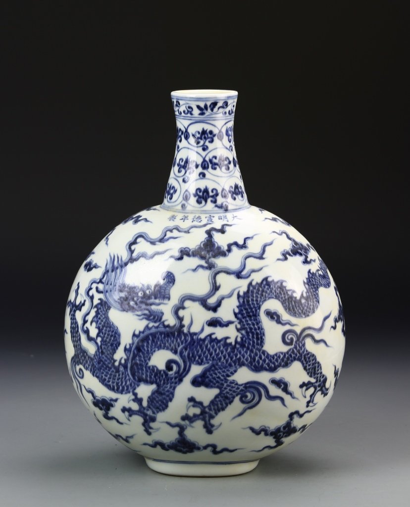 Chinese Blue and White Flask Vase: China, Qing Dynasty, blue and white moon flask vase, small mouth, long neck, round body on footed base decorated with a dragon amid flames and clouds. Height 10 1/4 in.
