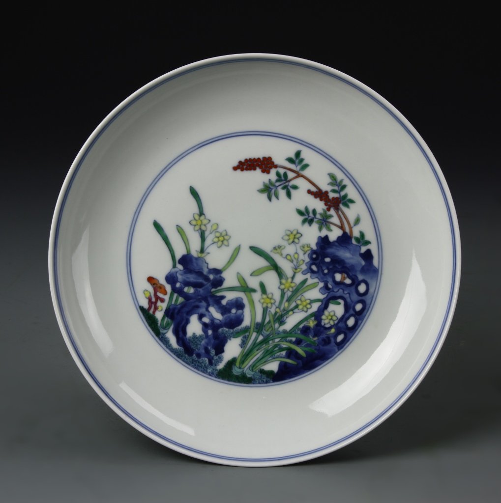 Fine Dou-T'sai Dish, Yung-Cheng: The curved sides painted in the interior with flowering orchid, red berries, and lingzhi emerging from pierced garden rocks, the exterior painted with further three clusters of flowering plants issuin