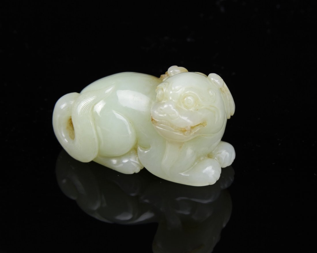 Chinese Jade Mythical Animal: China, jade mythical animal, in reclining position, deeply carved, with striations in the stone, in a light green hue, with brown, and smooth surface. Length 2 in., Width1 1/2 in. Provenance: From pri