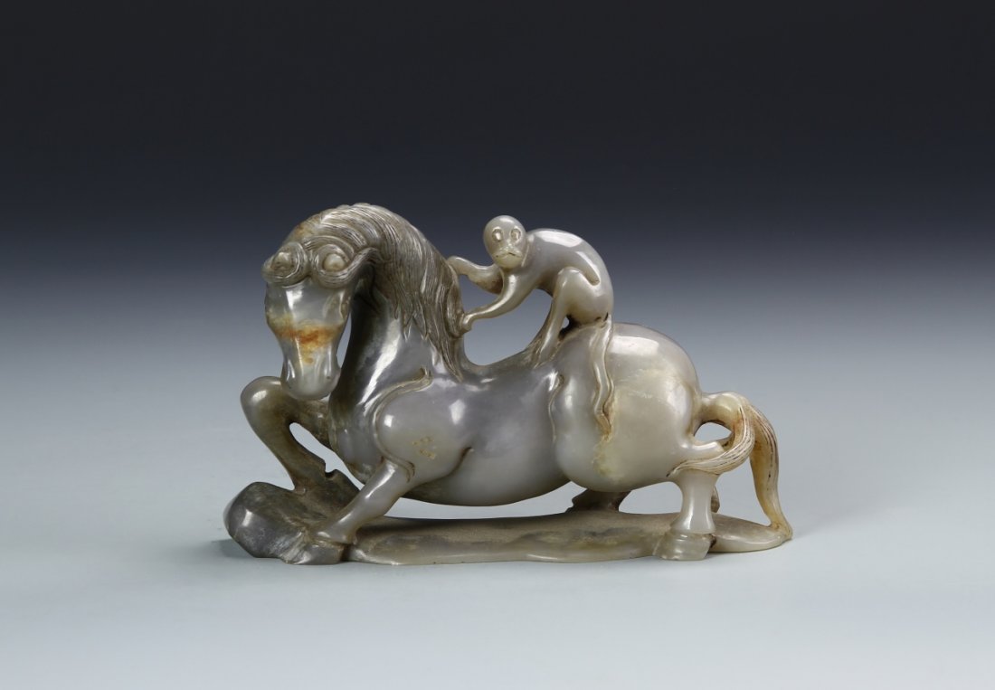 Chinese Jade Horse: China, ROC Period, Jade Horse with Monkey, horse in a lunging position with monkey riding on horse's back, holding onto the mane, intricately carved detail on mane, in gray hue, on base. Length 6 in.,