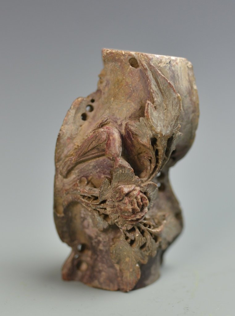 Chinese Jade Vase: China, antique jade vase, in a naturalistic form, with deeply carved floral motifs, in a mottled red-brown hue, and striations in the stone. Height 4 1/4 in.