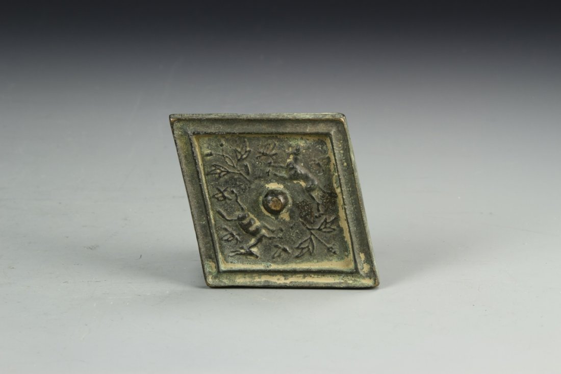 Chinese Bronze Pocket Mirror: China, antique, bronze pocket mirror, diamond shaped form with central raised bump and lined border, with deer and wildlife symbols on the front. Length 3 1/4 in., Width 4 1/4 in.
