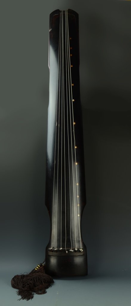 Chinese Wood Music Instrument: China, antique wood music instrument, tall, oblong body in shiny, dark wood with seven attached and tied strings from top to bottom. Length 50 in.