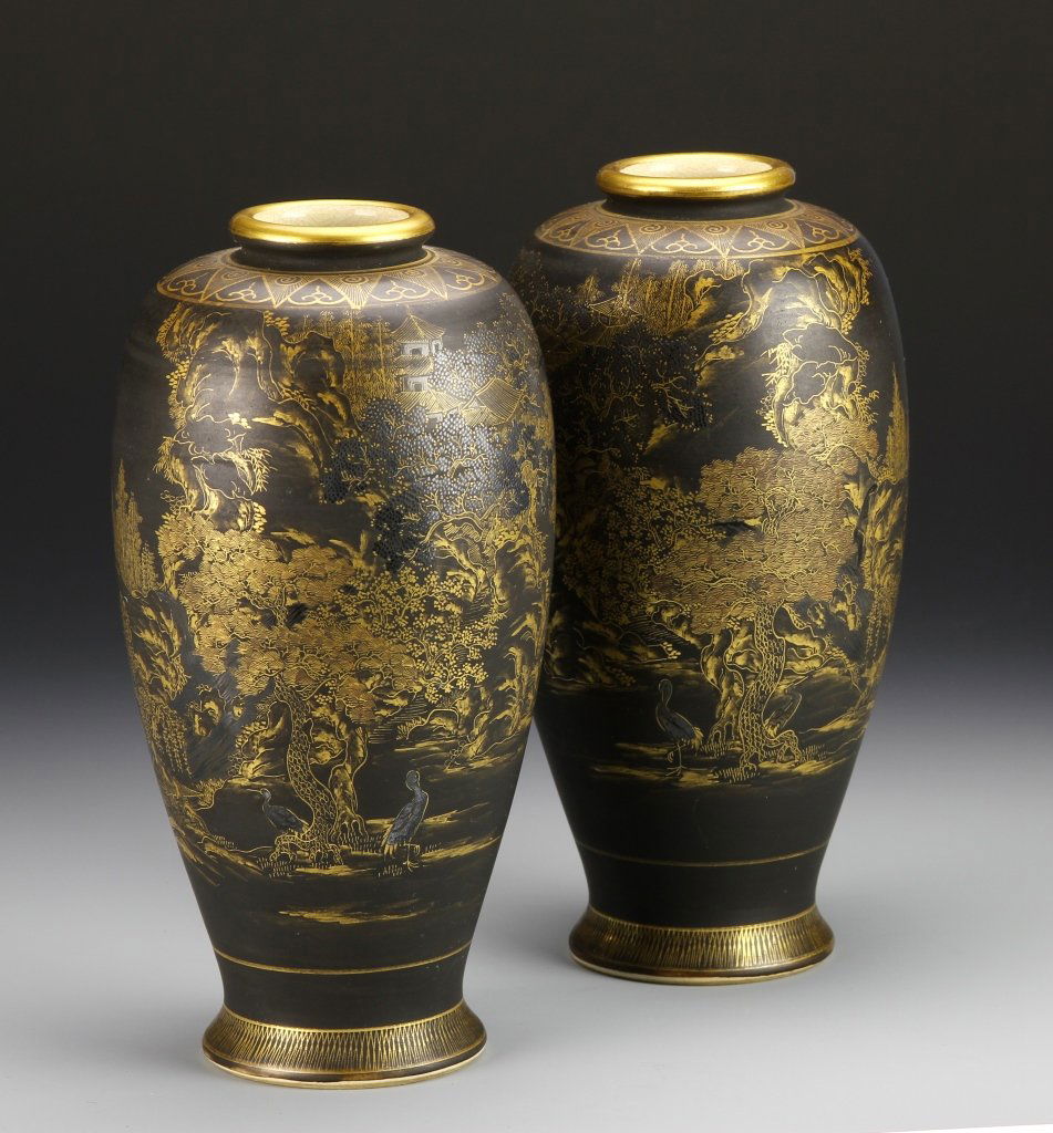 Pair of Japanese Satsuma Vases: Japan, antique pair of Satsuma vases, rounded rim, long slightly curved body, footed base, beautifully decorated with gold on black ground, trees, birds and homes. Height 9 in. Provenance: From the pr