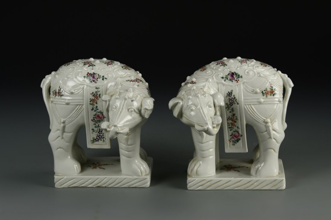 Pair of French Porcelain Elephants: French, a pair of porcelain elephants, matching elephants who are standing facing one side with trunks low, with etched designs around body on flat square base. Height 7 in., Width 7 in.