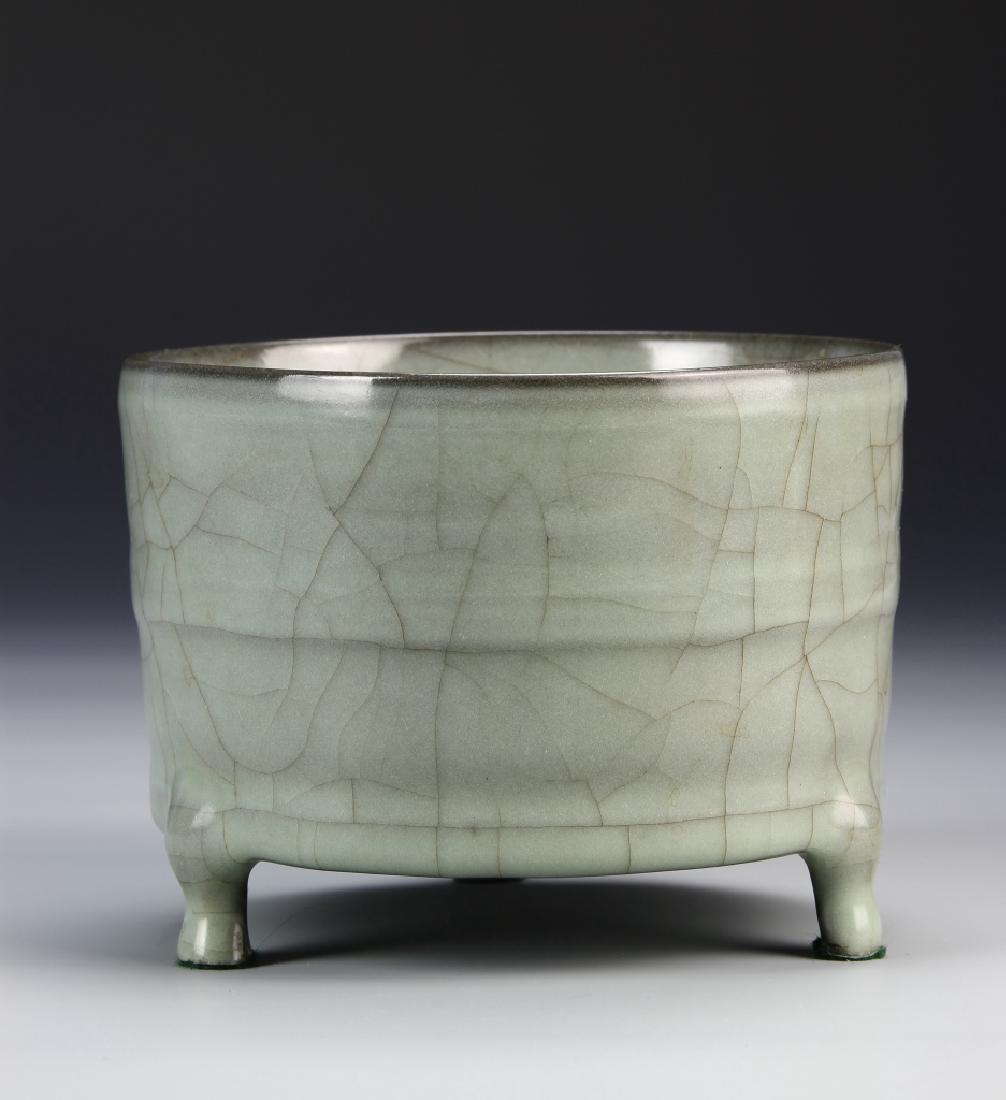 Lungch'uan K'uan-Type Tripod Censer: Of cylindrical body with raised bands, supported on three short legs, covered allover with a lustrous bluish-green glaze suffused with golden russet crackles, five spur marks on the base,5.3 inches di