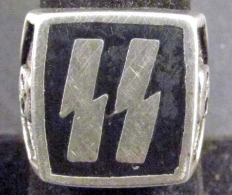 Nazi German Waffen SS Officers Ring: You are bidding on a Waffen SS Officers Ring. The ring measures 11/16" in diameter. The front has a pair of SS runics in the center. There is a human skull on each side. Nickel and black enamel constr