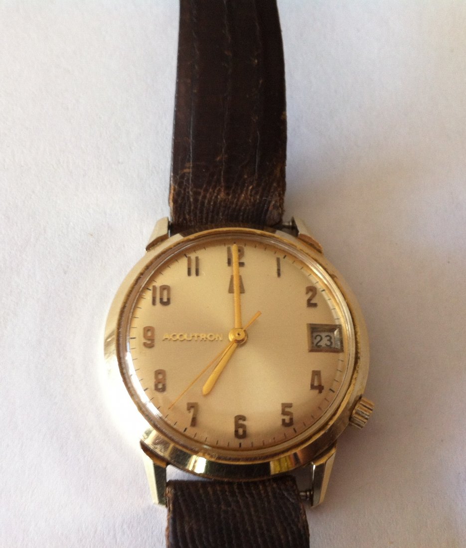 14 karat gold, Accutron Watch: Accutron Watch, 14 karat gold case, by Bulova. Waterproof. Time and Date functions. No. F23844.