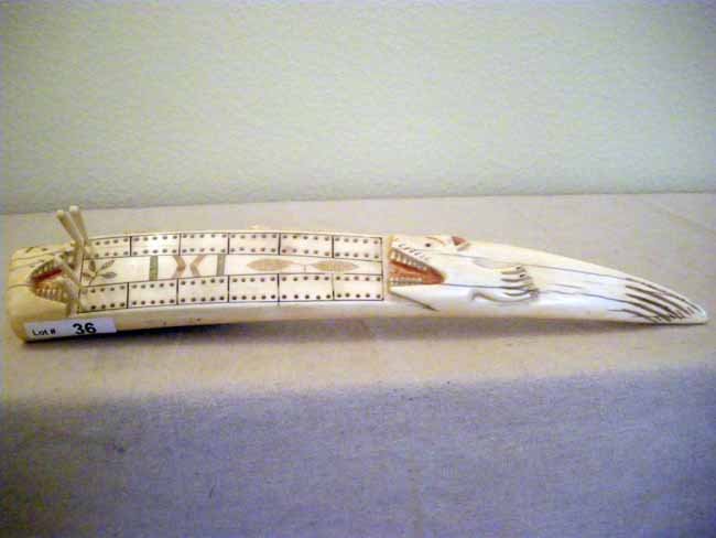 Carved Alaskan Ivory Walrus Cribbage Game Boar: A fine example of carved Native Alaskan walrus ivory in a cribbage game board accented with color & highlighted details, measuring 14 ½" length.