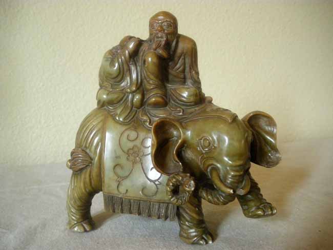 Asian Carved Soapstone Elephant with Male Figures : A finely carved soapstone Asian elephant with two male figures seated atop, measuring 6 ½" high.