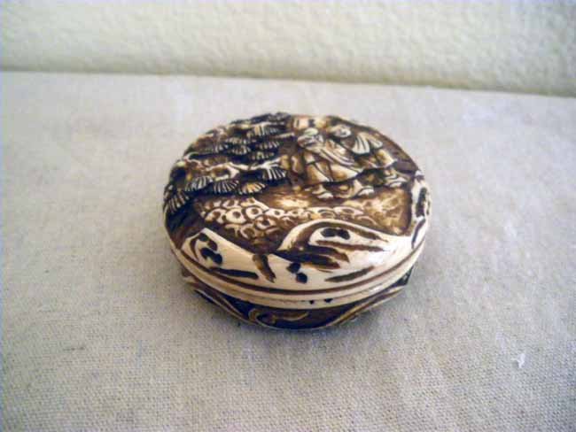 Ivory Nutske Box with Carved Interior: A round netsuke accented with a carved interior, signed, measuring 2 ½" diameter