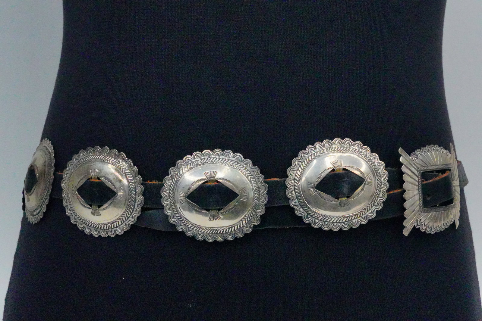 Native American Sterling Silver and Leather Concho Belt: Native American Vintage Sterling Silver and Leather Concho Belt - This belt is comprised of sterling silver conchos on a black leather belt. The conchos are decorated with ornate tribal stamp work, sh