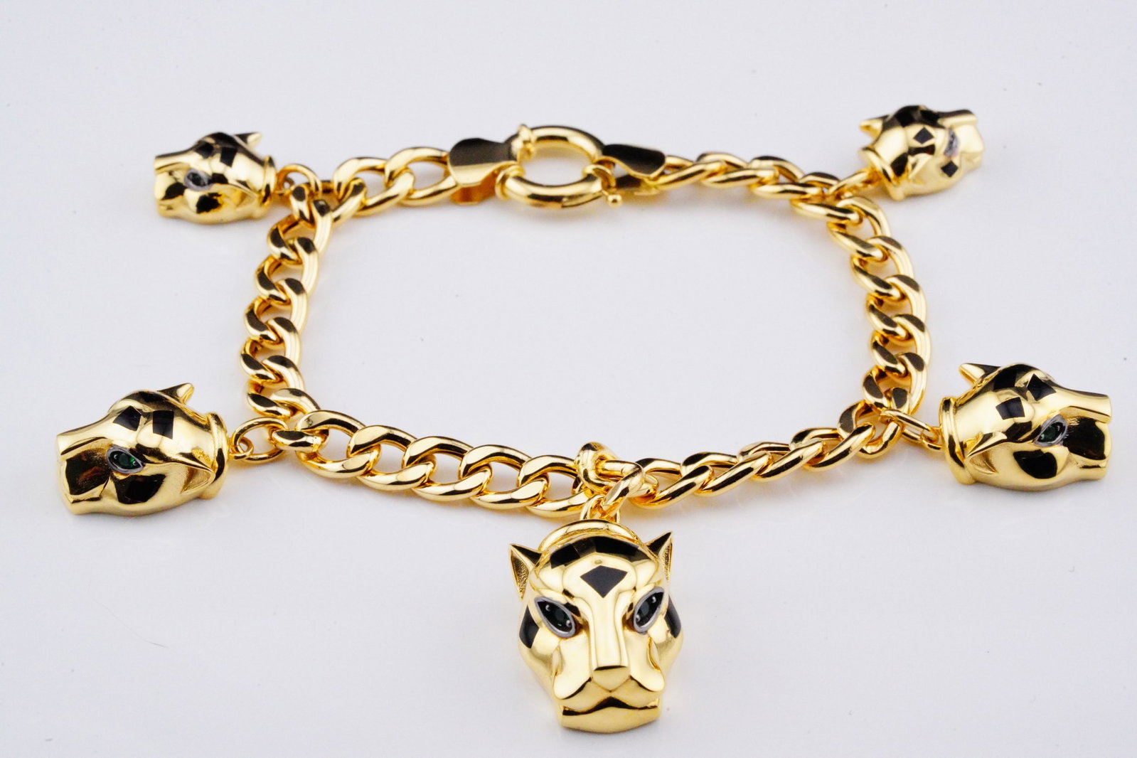 18K Yellow Gold Panther Charm Bracelet: 18K Yellow Gold Panther Charm Bracelet W/Black Lacquer and Green Zircon Accents - This bracelet seamlessly combines the luxurious warmth of 18K gold with the intricate artistry of a panther motif, res