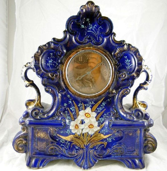 Vintage Hand Painted English Mantle Clock: The clock is a beautiful royal blue color with gold accents. There are flowers on the front. The bottom has a backstamp & says "England". The clock is in good working condition. Approx. 17"x18" Est. v