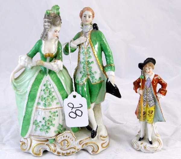Lot of (2) Vintage Sitzendorf Figurines: Both of the pieces have the Sitzendorf back stamp of a crown over an S. There is one figurine that depicts a rich man. He is wearing elegant clothes & a long red cloak. The bigger figurine has some re
