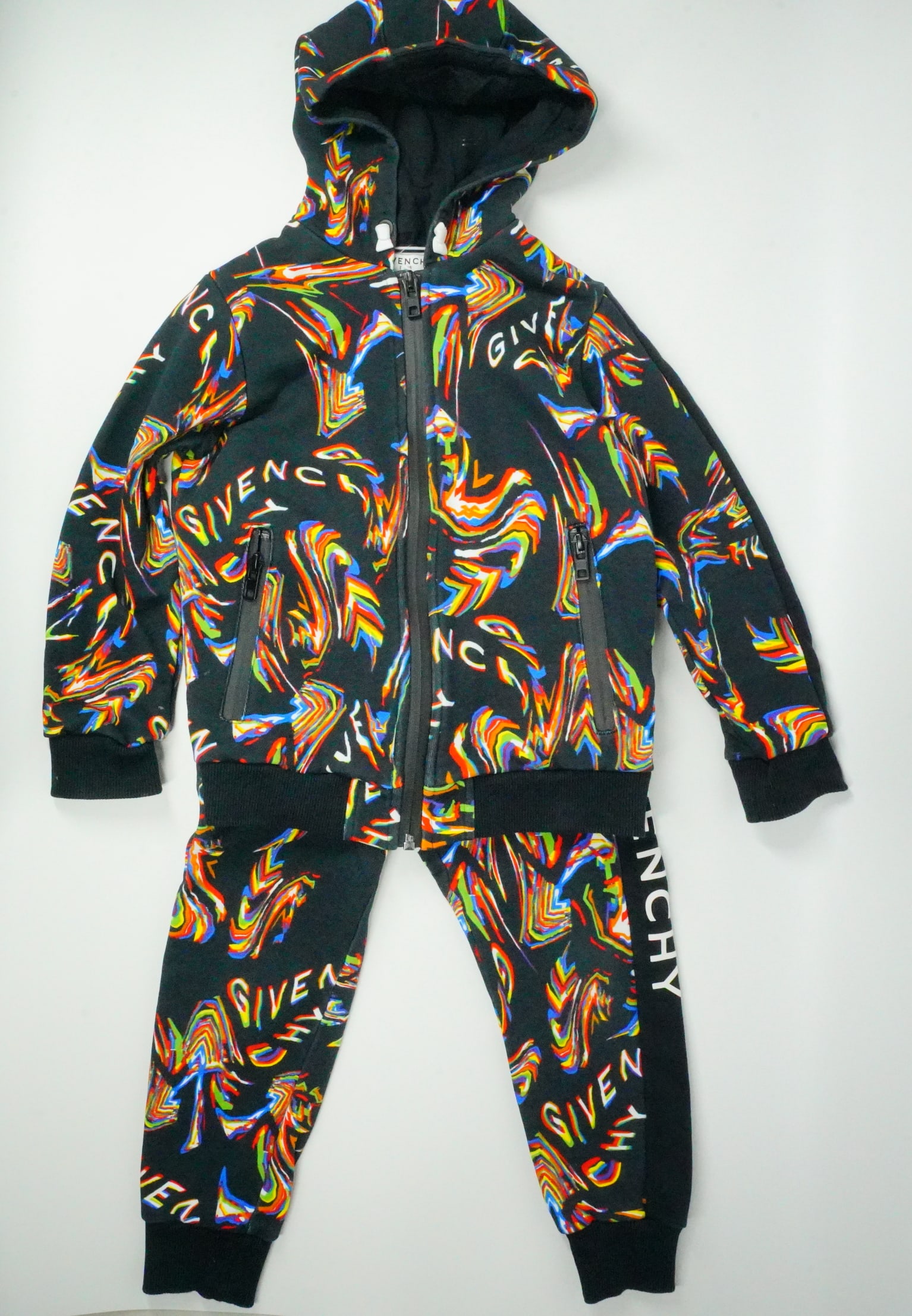Givenchy Children's Graphic Black Jogging Set: GUARANTEED AUTHENTIC. Givenchy Children's Graphic Black Jogging Set with Hoodie - This jogging set features an all-over glitch logo graphic print and a center front zip closure. The sweatshirt include