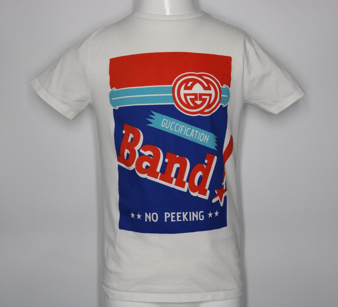 Gucci Children's Guccification Band Print T-Shirt: GUARANTEED AUTHENTIC. Gucci Children's Guccification Band Print T-Shirt, White - This t-shirt features a bold "Guccification" band print, making a statement with its unique and recognizable design. It