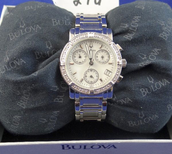 Ladie's Bulova Chrono Watch W/Diamond Bezel: Ladies Bulova Chronograph Watch, with Diamond Bezel in Original Box. The band is stainless steel, has date display, the watch is new & in original box, in working condition