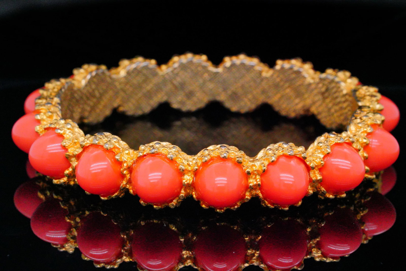 Pauline Rader Vintage Gold Tone Bangle W/Faux Coral: Pauline Rader Vintage Hinged Gold Tone Bangle W/Faux Coral - This striking vintage bangle by Pauline Rader exemplifies her signature fusion of classical inspiration and bold design. Crafted in richly