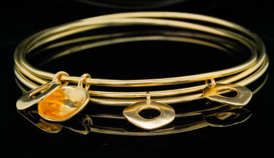 Ippolita Lot of (3) 18K Yellow Gold Charm Bangles: Ippolita Lot of (3) 18K Yellow Gold Charm Bangles - This lot includes (3) Ippolita bangle bracelets in solid 18k yellow gold. Each bangle is finished with hanging circle charms. Hallmarks: Ippolita, 1