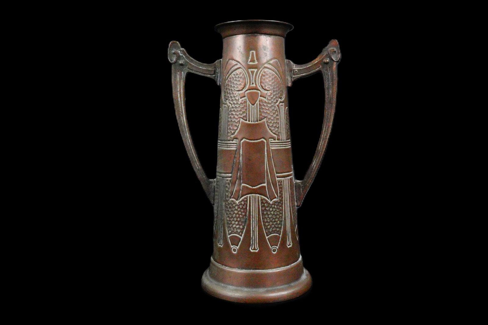 Arts and Crafts Era Embossed Copper Twin-Handled Vase: Arts and Crafts Era Embossed Copper Twin-Handled Vase - This striking Arts and Crafts period embossed copper vase features an elegant elongated body with stylized geometric and organic motifs in deep