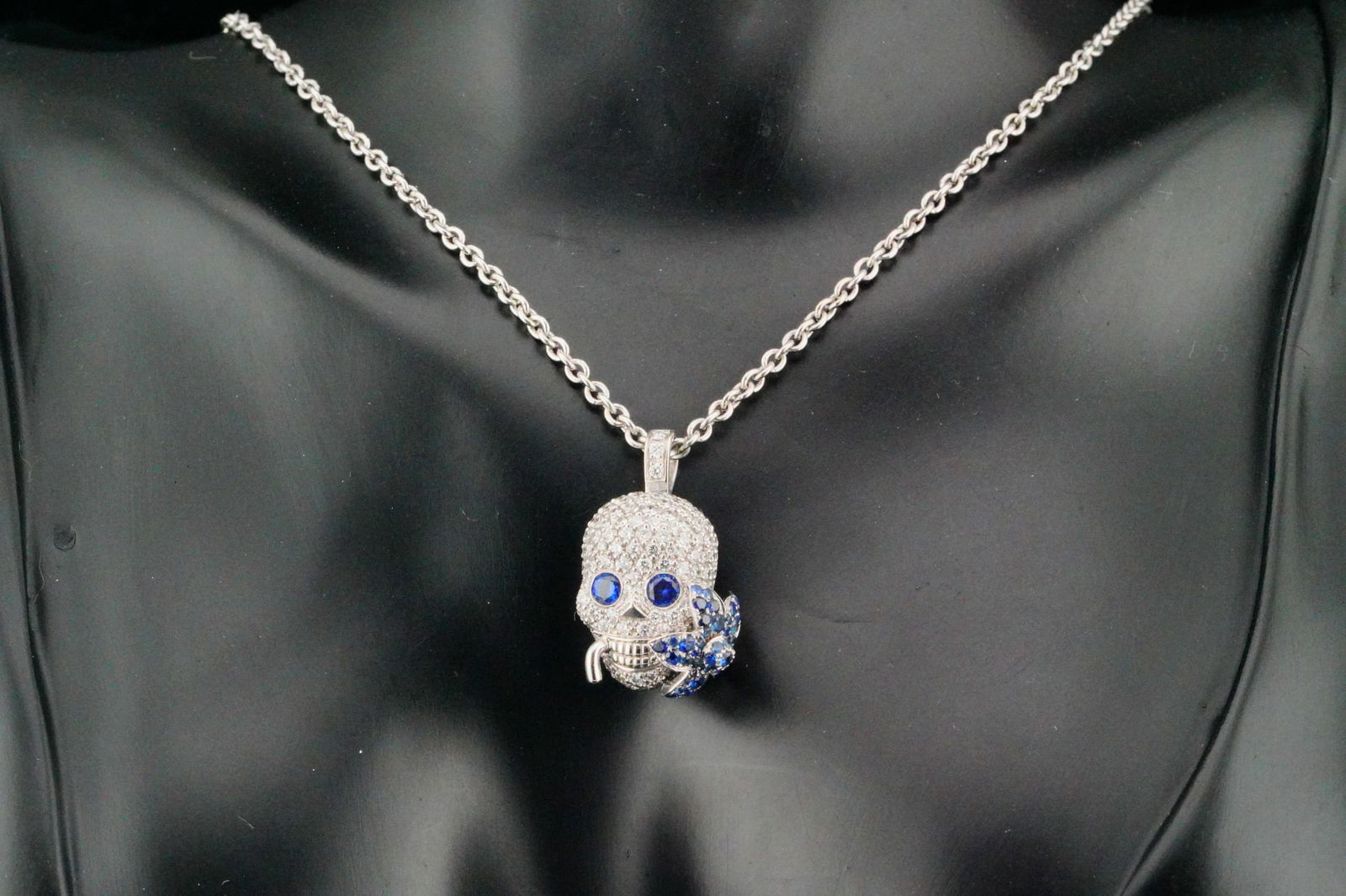 Gucci Flora 1.00ctw Diamond, Sapphire 18K Necklace: Gucci Flora 1.00ctw Diamond and Blue Sapphire and 18K White Gold 23" Skull Pendant Necklace - This lovely piece from Gucci's Flora collection features a meticulously crafted skull pendant hanging from