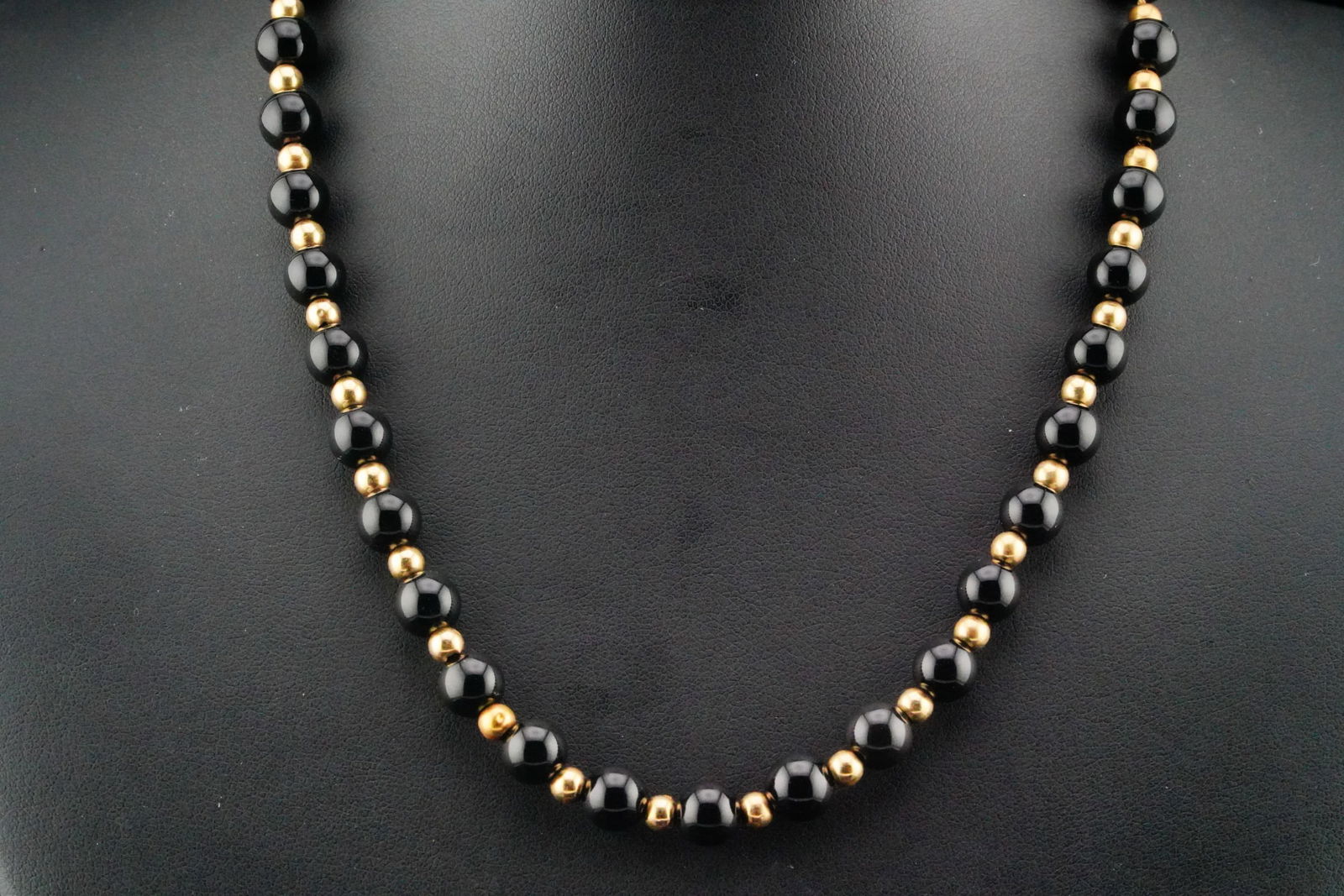 7mm Onyx Bead and 14K Yellow Gold 16" Necklace: 7mm Onyx Bead and 14K Yellow Gold 16" Necklace - This classic necklace features polished 7mm round onyx beads, evenly spaced with warm 14K yellow gold bead accents. The deep black luster of the onyx