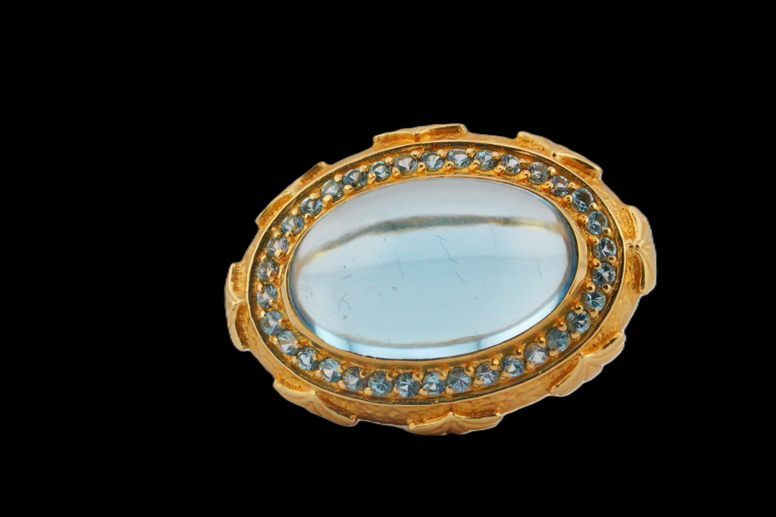 17.8mm Blue Topaz, 14K and 0.60ctw Blue Topaz Ring: 17.8mm Blue Topaz, 14K Yellow Gold and 0.60ctw Blue Topaz Ring - This striking statement ring is crafted in solid 14K yellow gold and features a large oval cabochon blue topaz measuring approximately