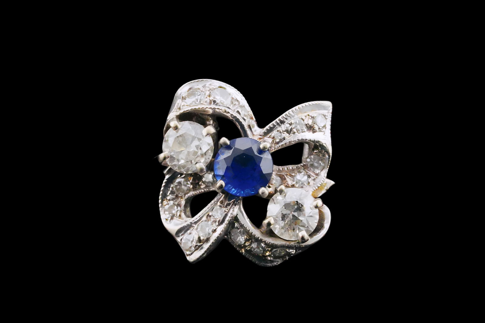 Vintage 0.80ctw Diamond, 0.40ct Sapphire and 14K Ring: Vintage 0.80ctw Diamond, 0.40ct Blue Sapphire and 14K White Gold Bow Motif Ring - Charmingly designed in 14K white gold, this elegant vintage ring features a graceful bow motif set with sparkling diam