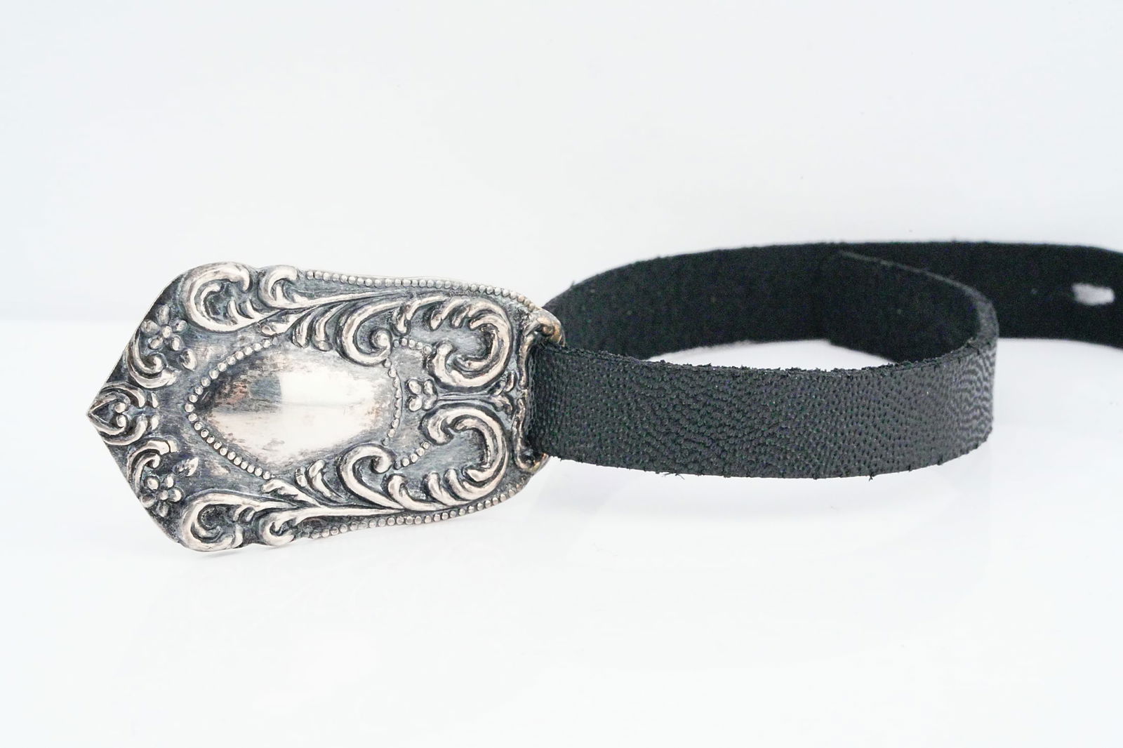 Vintage Sterling Silver and Leather Luggage Tag: Vintage Sterling Silver and Leather Luggage Tag - An elegant vintage sterling silver luggage tag featuring an ornate repousse-style tag with scrolling foliate motifs and a central shield-shaped cartou