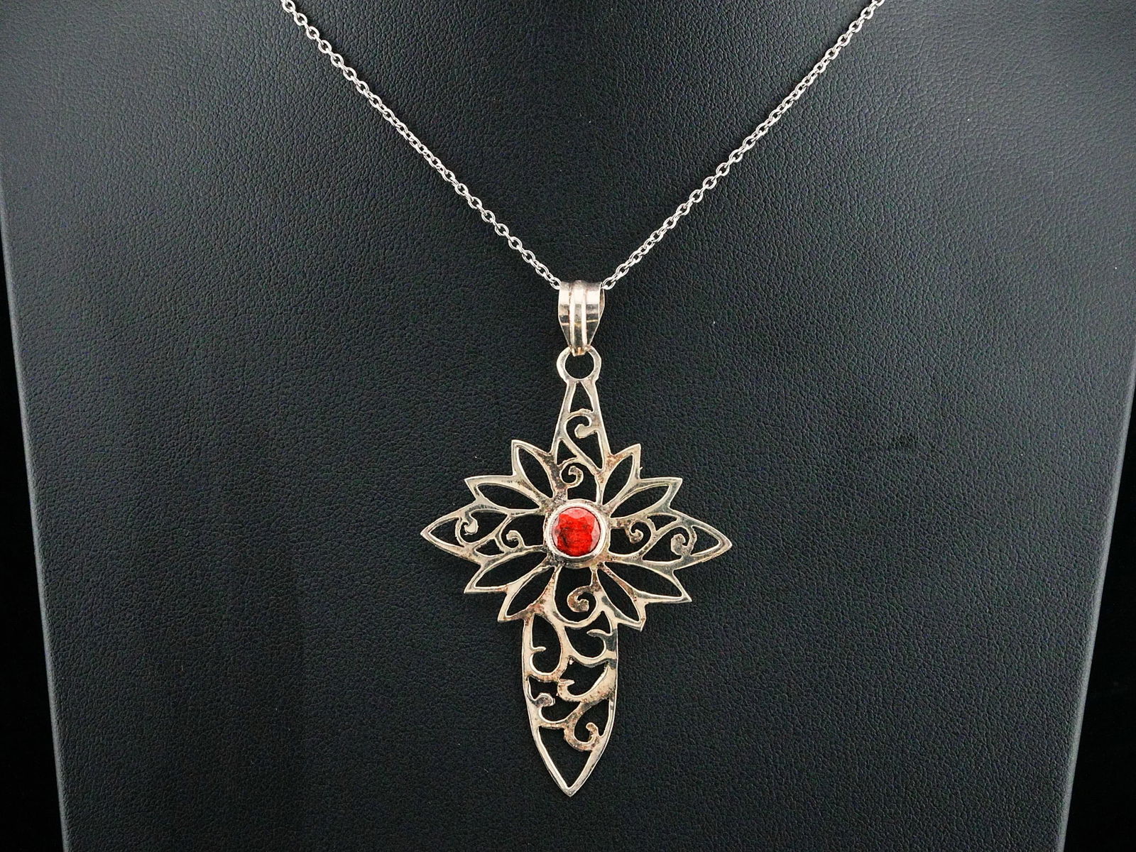 1.00ct Ruby and Sterling Silver 20" Cross Necklace: 1.00ct Raw Ruby and Sterling Silver Openwork 20" Cross Pendant Necklace - This striking pendant necklace is crafted in solid sterling silver and showcases an ornate openwork cross design centered by