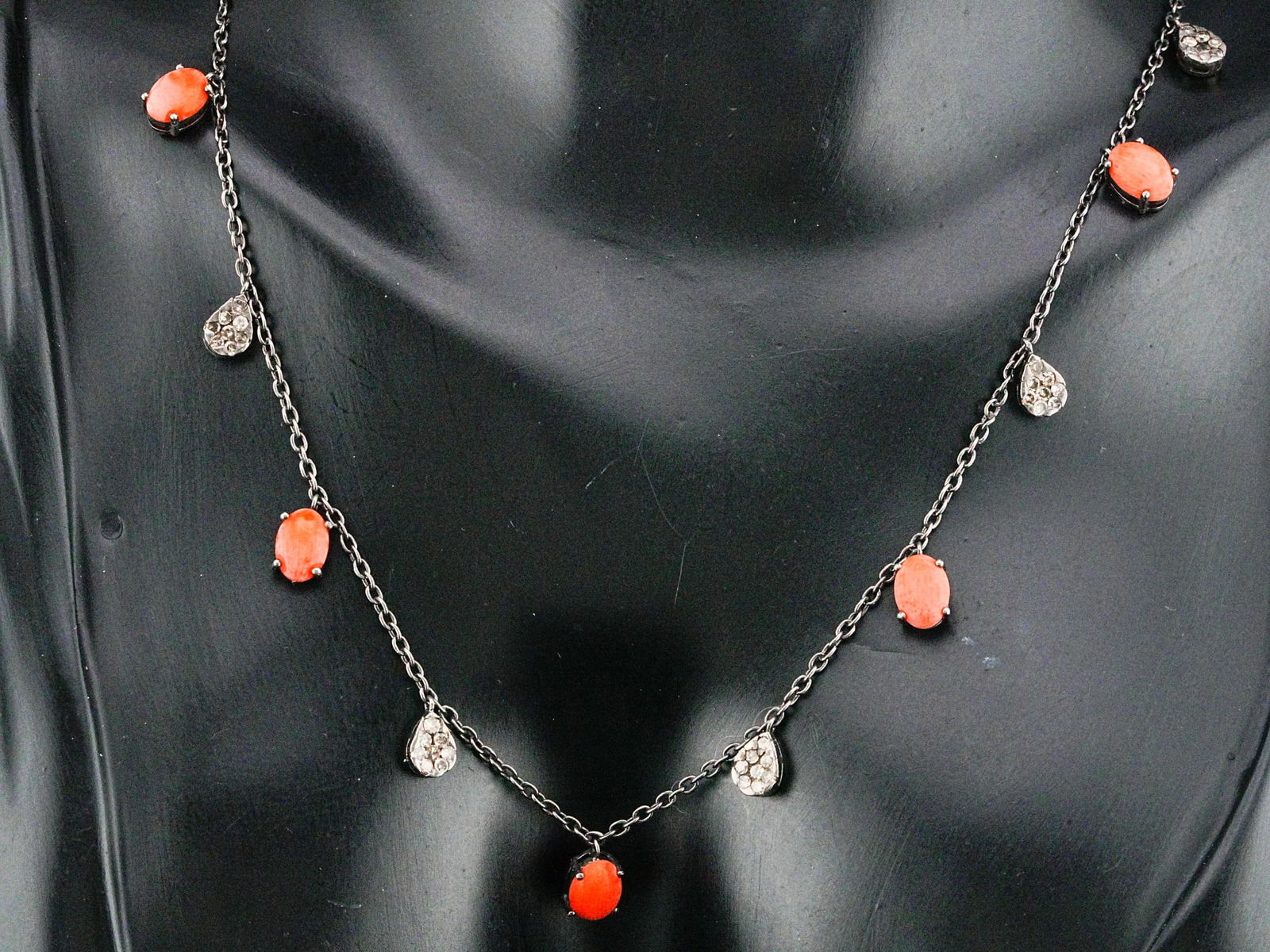 7mm Red Coral, 0.85ctw Diamond and Silver 18" Necklace: 7mm Red Coral, 0.85ctw Diamond and Silver 18" Necklace - This necklace is crafted in silver and decorated with 7mm red coral cabochons and 0.85ctw pave diamonds. Measurements: 18" length. Condition: V