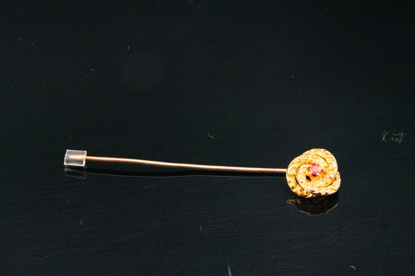 Vintage 10K Yellow Gold Ruby Accented Flower Stick Pin: Vintage 10K Yellow Gold Ruby Accented Flower Stick Pin - A charming vintage stick pin crafted in 10K yellow gold, designed as an elegant floral motif accented with a vibrant ruby at the center. The de