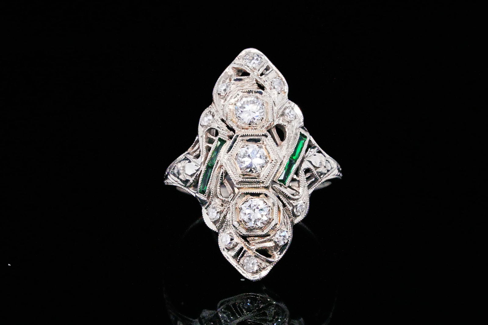 Art Deco 0.50ctw Diamond and 14K Ring W/Emerald Accents: Art Deco 0.50ctw Diamond and 14K White Gold Ring W/Emerald Accents - THIS ITEM WILL COME WITH A $5,000 INSURANCE VALUATION REPORT IN THE WINNING BIDDER'S NAME. A refined example of classic Art Deco el