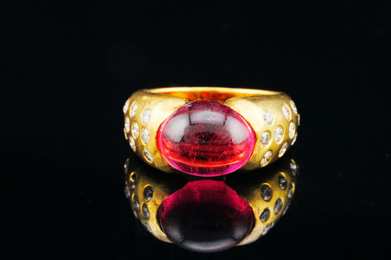 3.00ct Pink Tourmaline, 0.60ctw Diamond and 18K Ring: 3.00ct Pink Tourmaline Cabochon, 0.60ctw Diamond and 18K Yellow Gold Ring - A refined and elegant ring crafted in 18K yellow gold, showcasing a vivid pink tourmaline cabochon weighing approximately 3.